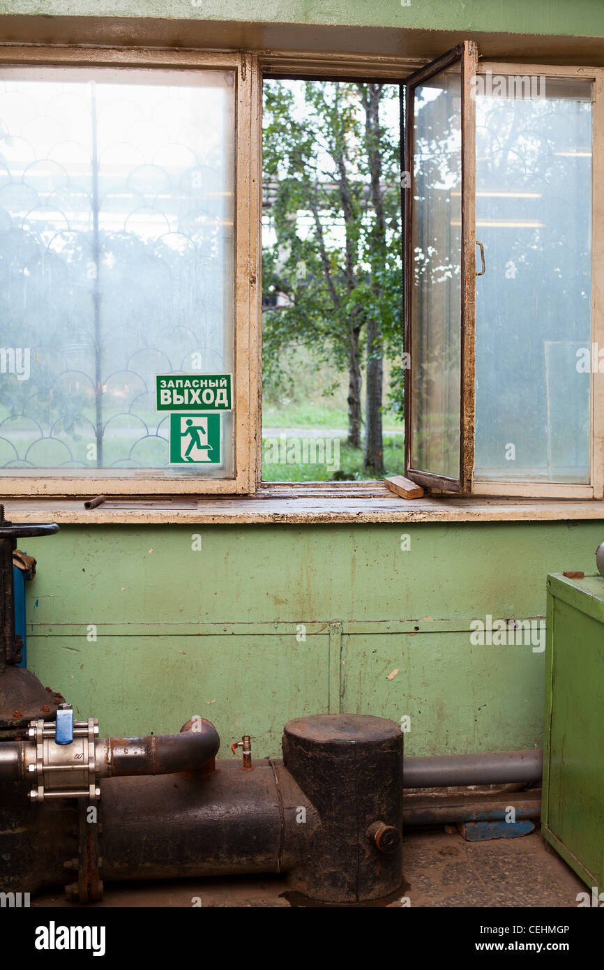 Iscrizione sul russo sulla piastra sul vetro del finestrino: "Uscita di emergenza". Ha aperto la porta finestra in camera industriale in fabbrica. La Russia Foto Stock