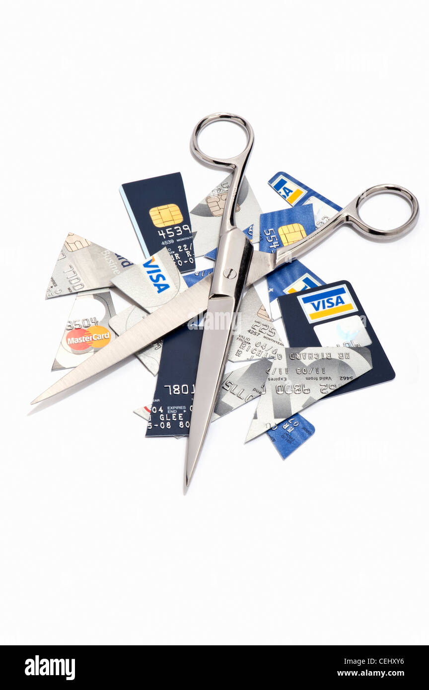 Carte di credito tagliato a pezzi e un paio di forbici Foto Stock