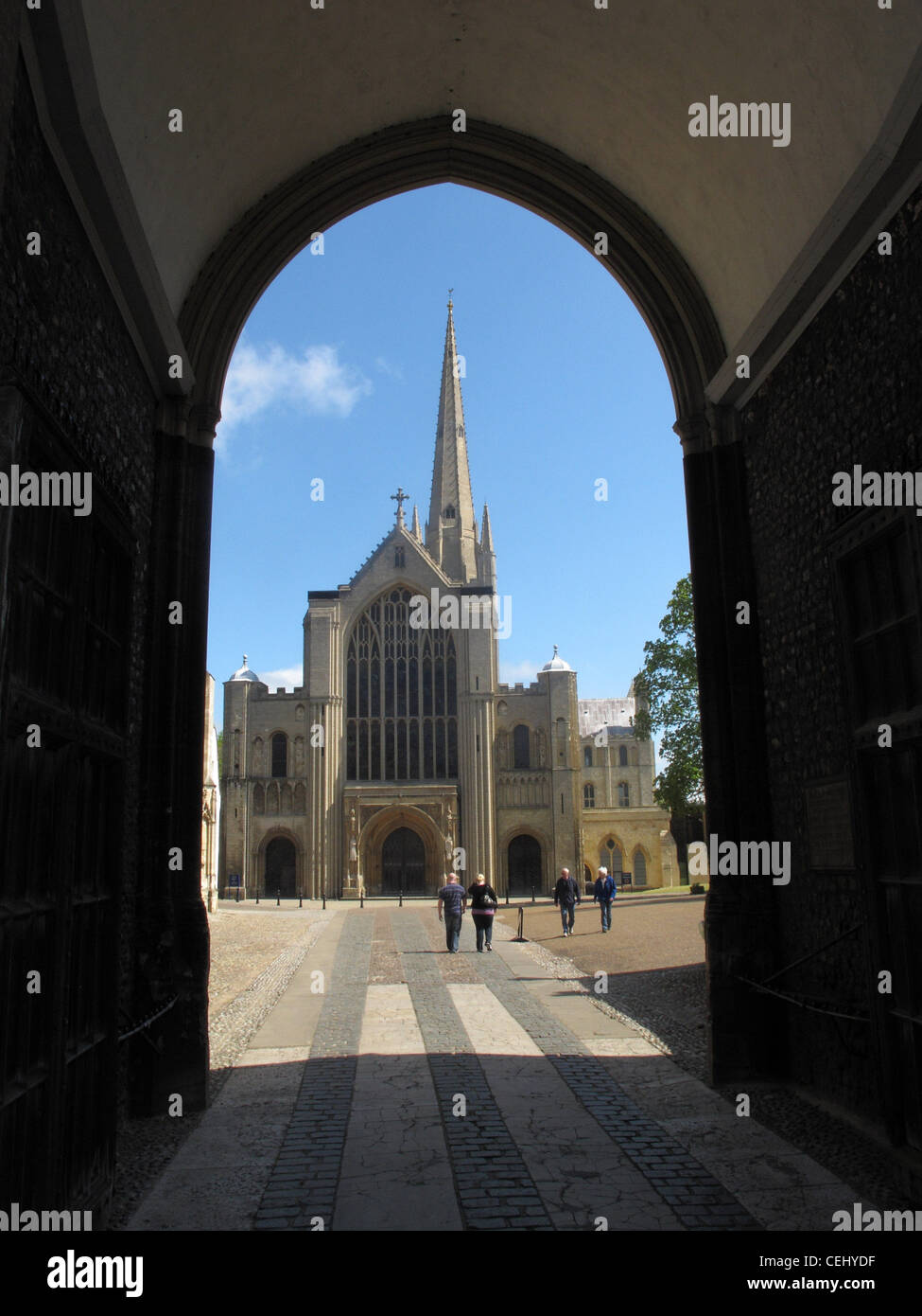 Norwich Cathedral, una vecchia 900 anni di ispirazione benedettina, normanno costruito centro di culto, osservata attraverso un arco. Foto Stock