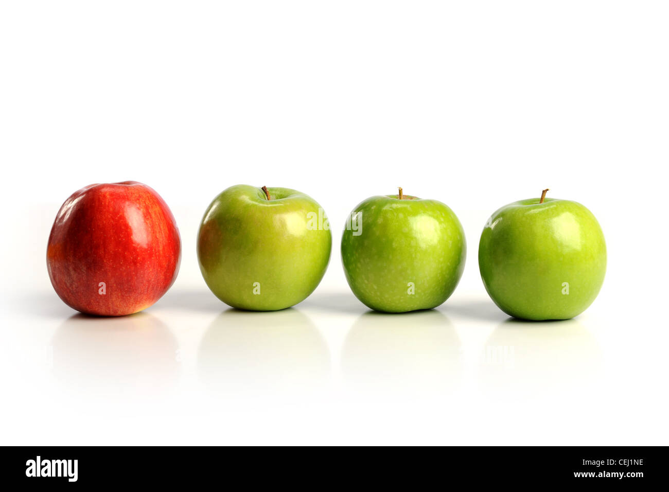 Red apple tra mele verdi isolati su sfondo bianco Foto Stock