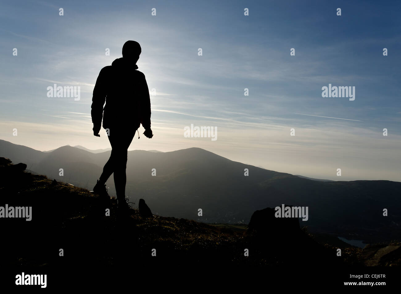 Una silhouette di una persona che cammina in montagna Foto Stock