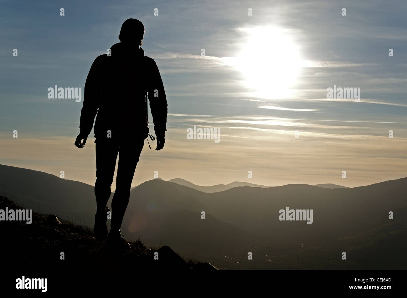 Una silhouette di una persona che cammina in montagna Foto Stock