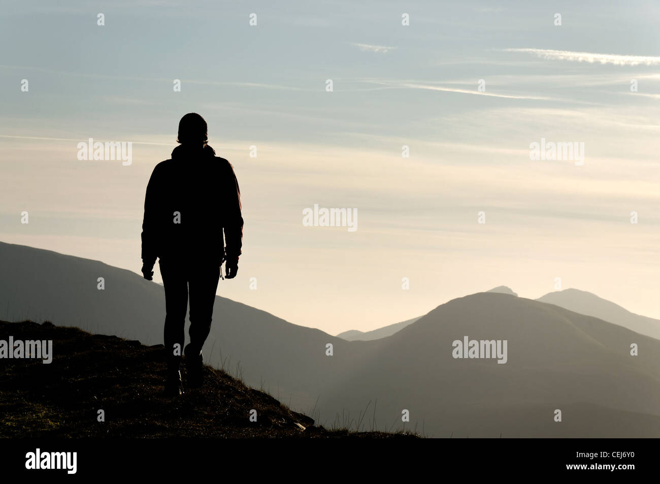 Una silhouette di una persona che cammina in montagna Foto Stock