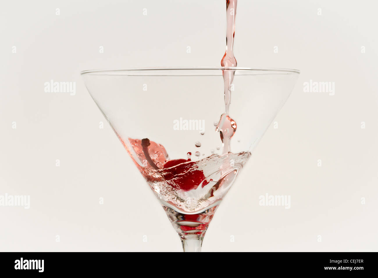 Red bere colata in erba con cherry isolati su sfondo bianco Foto Stock