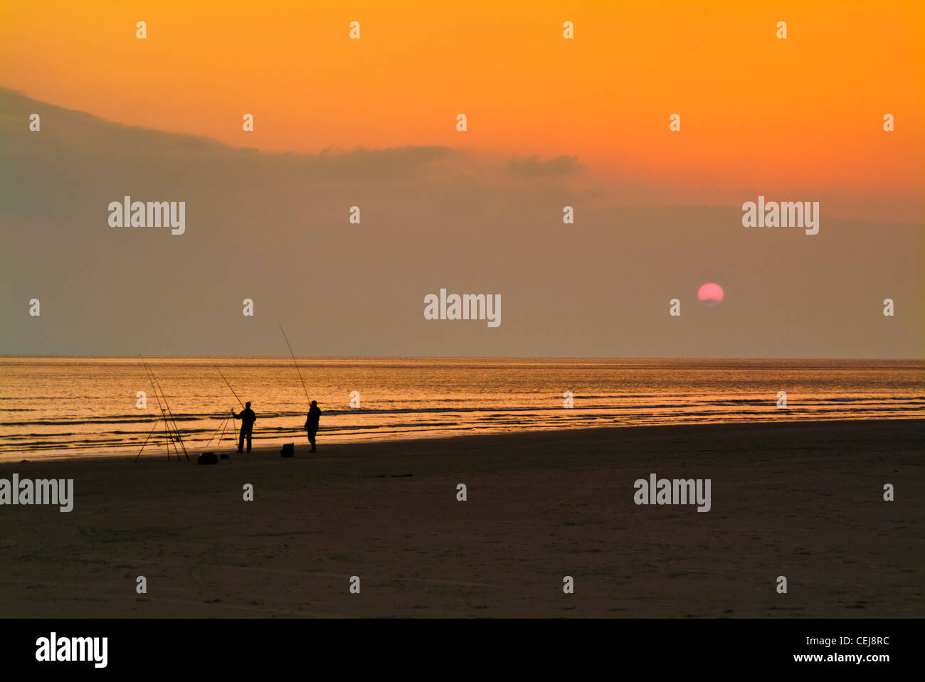 I pescatori di linee di impostazione per la pesca notturna su Tal y bont beach North Wales UK GB eu europe Foto Stock