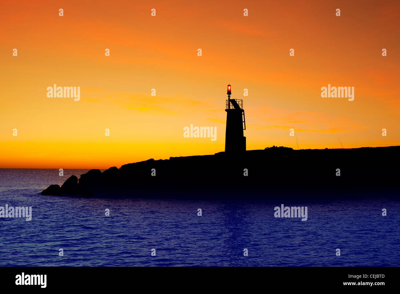 Golden sunrise tramonto nel mare rosso faro rotante nel Mediterraneo Denia Spagna Foto Stock