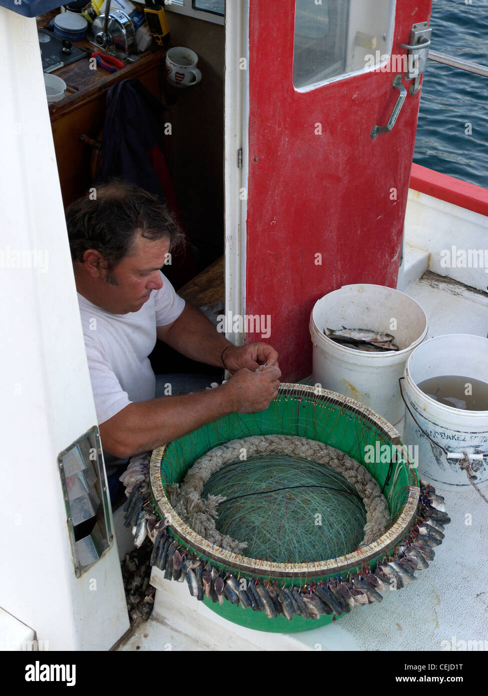 Grecia CICLADI sikinos un pescatore baiting una lunga fila di ganci Foto Stock