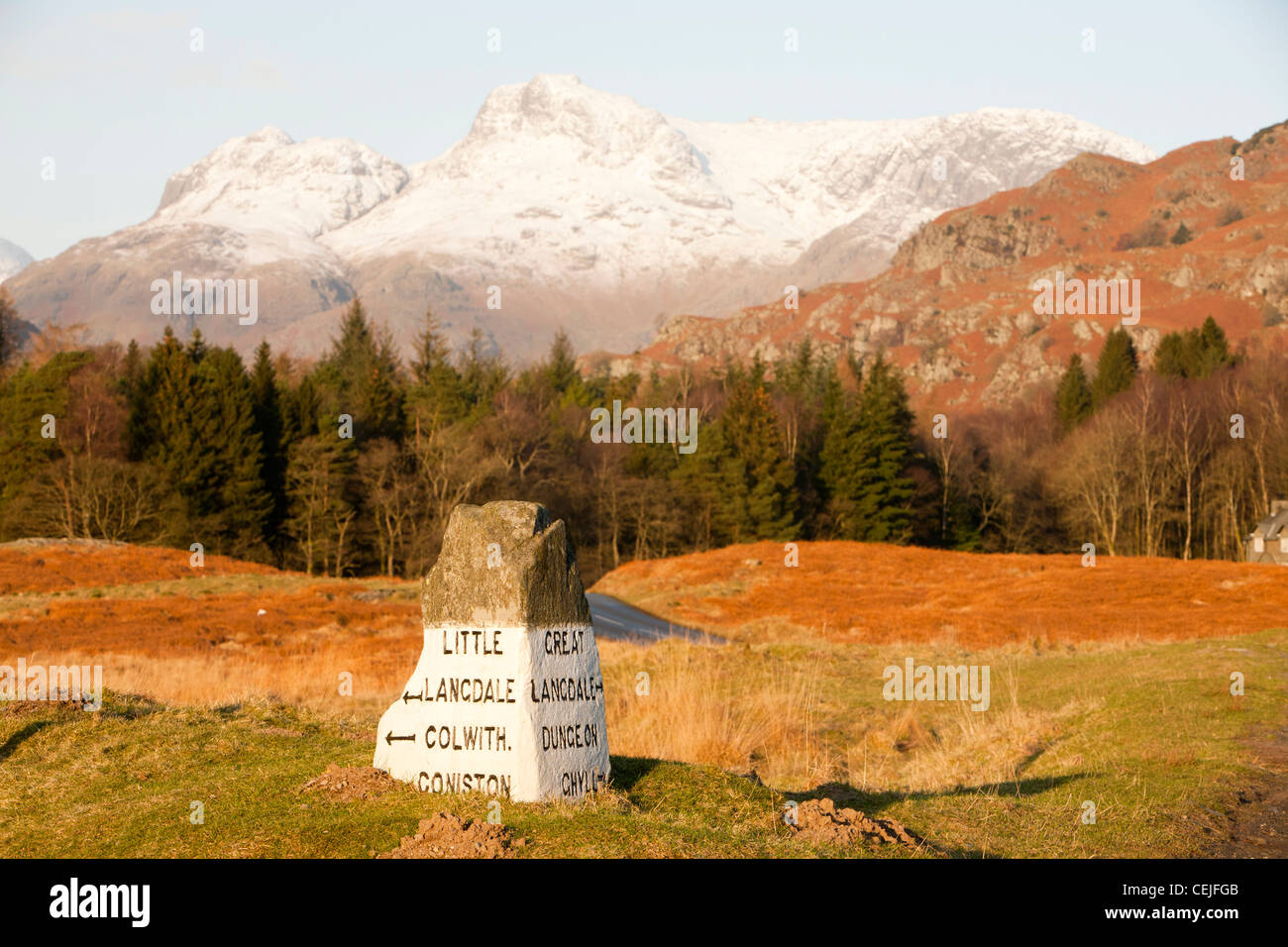 Un vecchio stone road sign in The Langdale valley a Elter acqua nel distretto del lago, UK, guardando verso il Langdale Pikes. Foto Stock