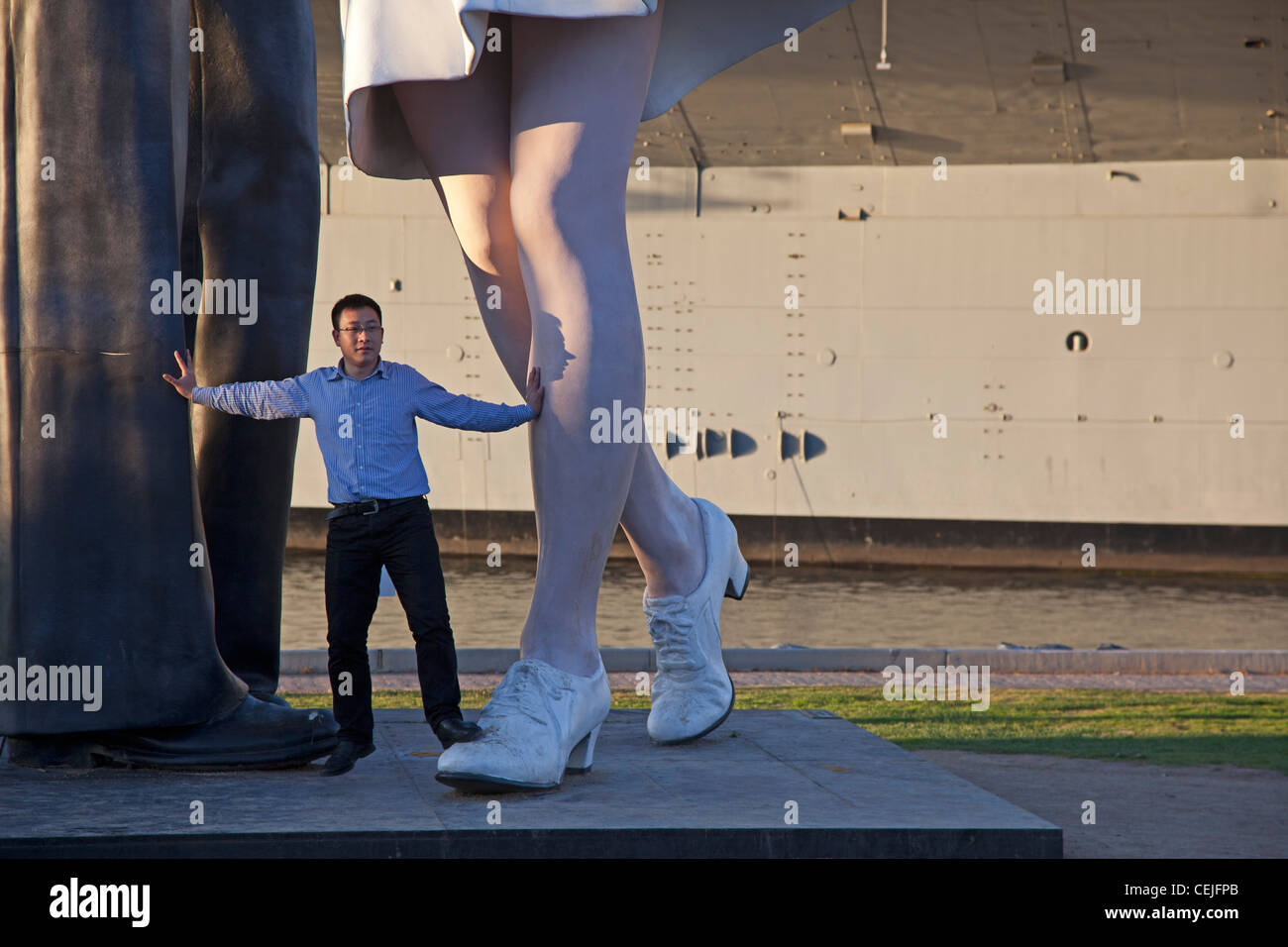 Tourist pone alla resa incondizionata statua Foto Stock