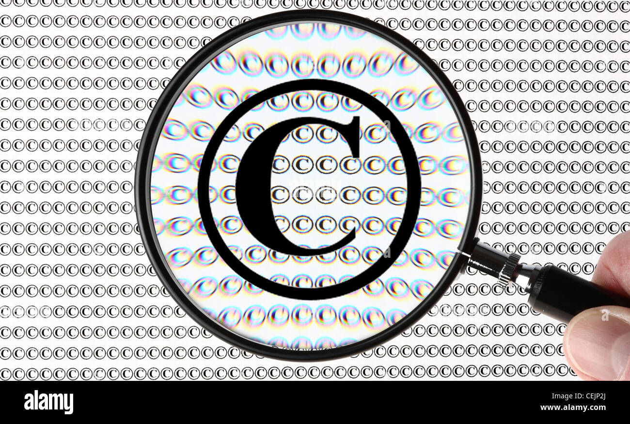 Lente di ingrandimento evidenziando un simbolo di copyright ©, © simbolo. Immagine simbolica. Foto Stock