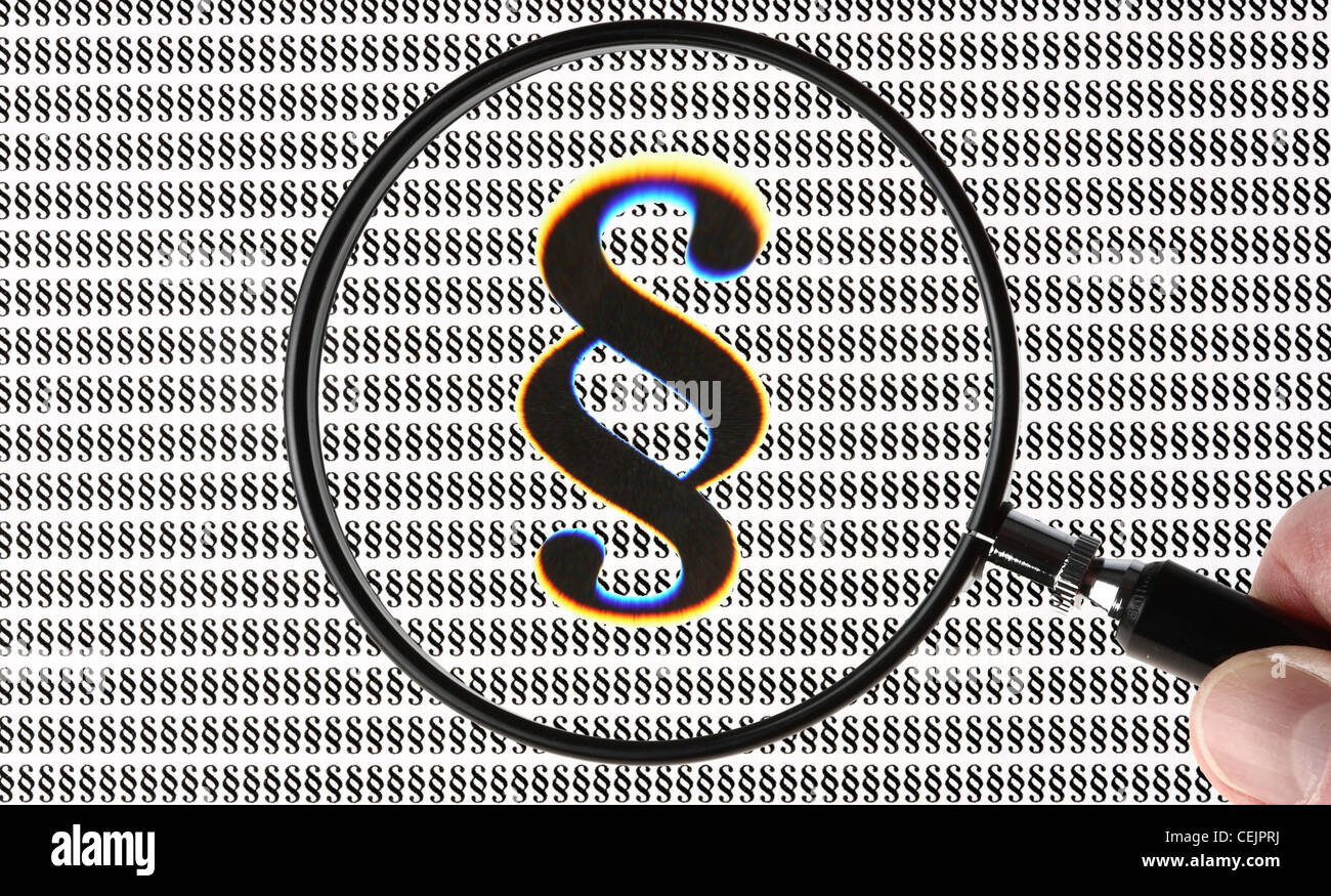 Lente di ingrandimento evidenziando un paragrafo simbolo, § segno. Immagine simbolica. Foto Stock
