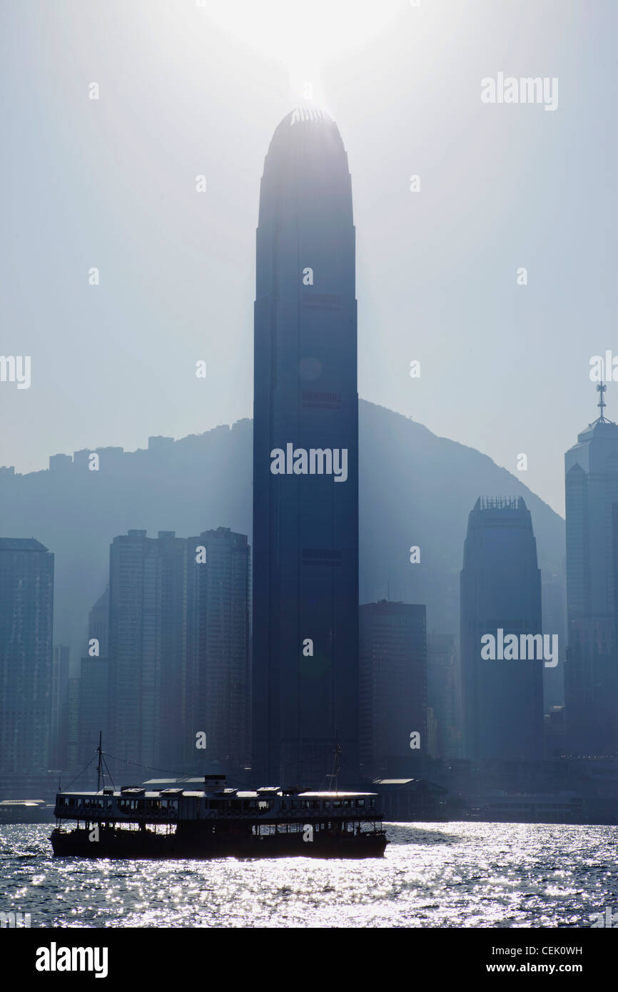 Sun burst off della finanza internazionale edificio. Skyline della città e il Victoria Peak di Hong Kong, Cina Foto Stock