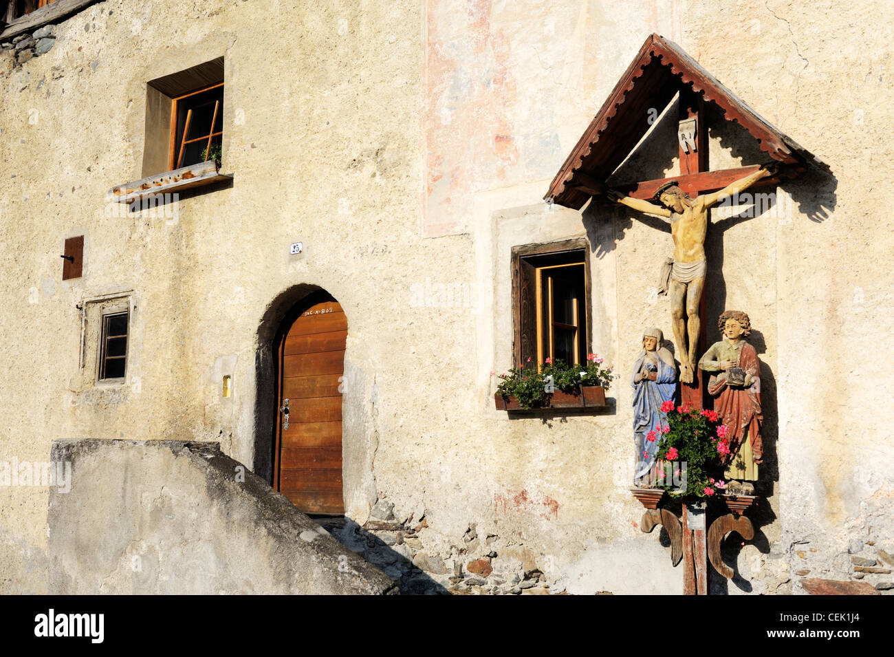 Crocifisso sulla parete della vecchia casa nel villaggio di Tarces vicino a Glorenza. La Val Venosta, Alpi Italiane, Italia Foto Stock