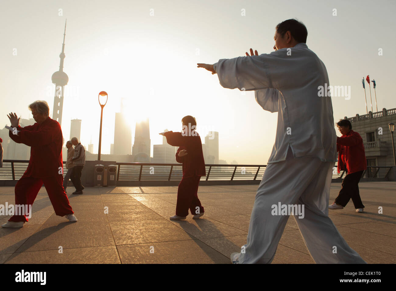 Persone che fanno di Tai Chi sul bund al mattino, Shanghai, Cina Foto Stock