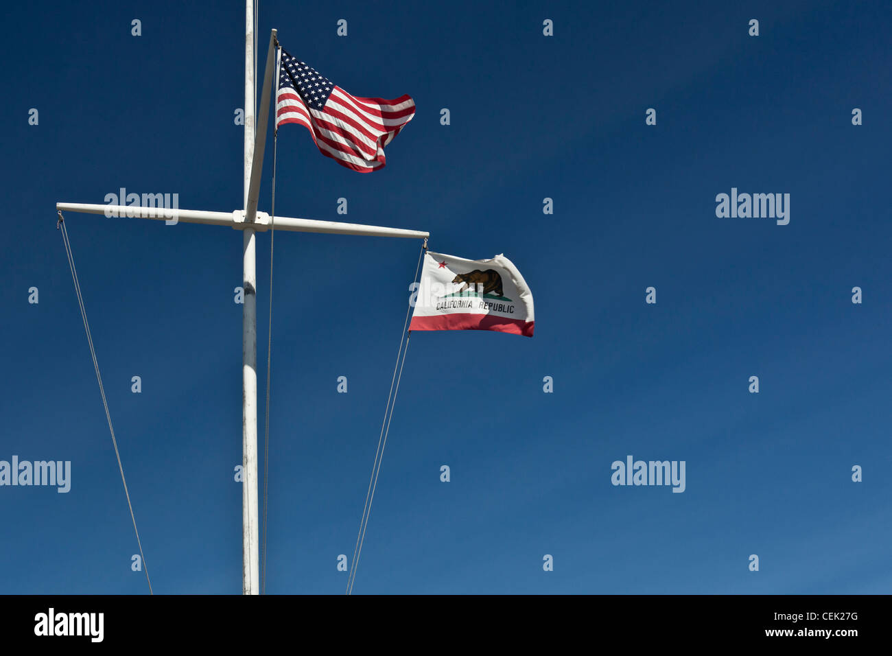 Noi la bandiera e la bandiera di Stato di California onda da una nave-montante bandiera in stile palo in corrispondenza del pilastro Point Marina vicino a San Francisco, CA. Foto Stock