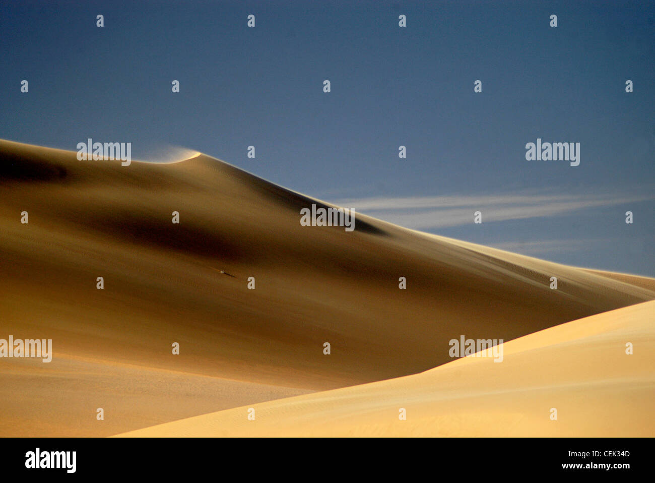 Soffiatura di sabbia su una solitaria duna di sabbia nel grande mare di sabbia. Foto Stock