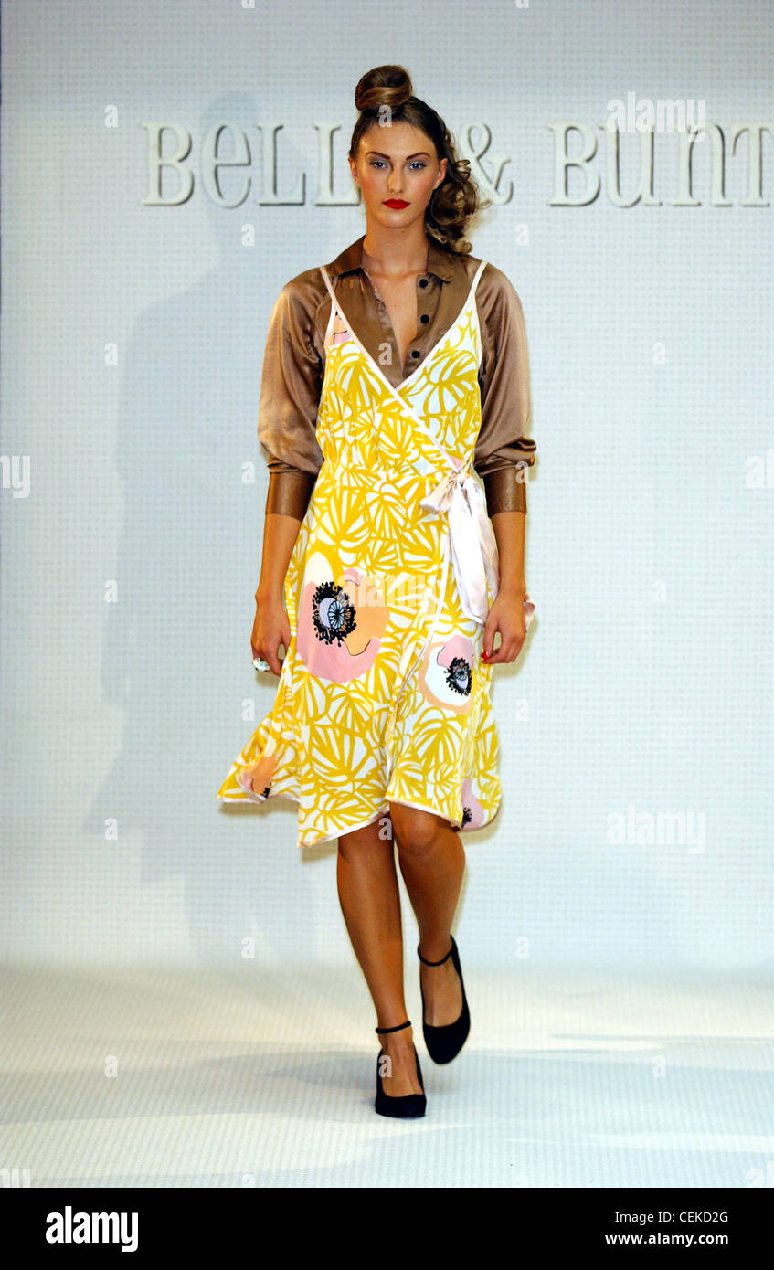 Belle e Bunty Londra pronto a indossare S S Wrap stampa giallo strappy abito e camicetta in raso Foto Stock