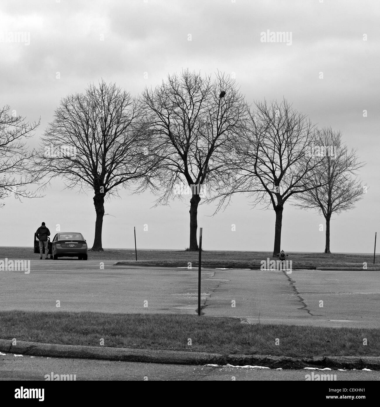 Un uomo e la sua auto sono i soli segni di vita a Milwaukee il lungolago in un nuvoloso pomeriggio. Foto Stock Un uomo e la sua auto sono i soli segni di vita a Milwaukee il lungolago in un nuvoloso pomeriggio. Foto Stock