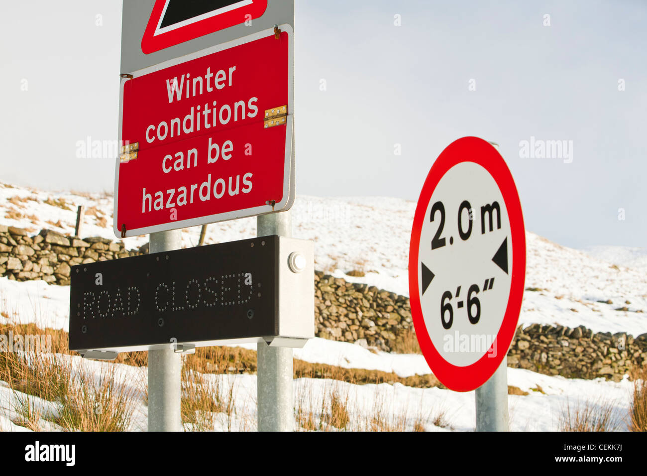 Un cartello stradale a Kirkstone Pass summit in inverni neve, Lake District, UK. Foto Stock