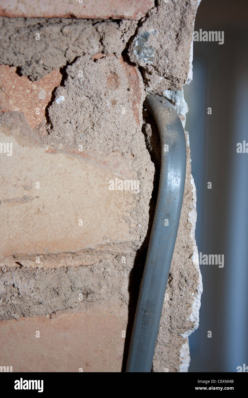 La costruzione, la costruzione di un 1930s house mostrando vivo i fili elettrici e pericolosi i rischi prima di seguenti regolamenti edili Foto Stock