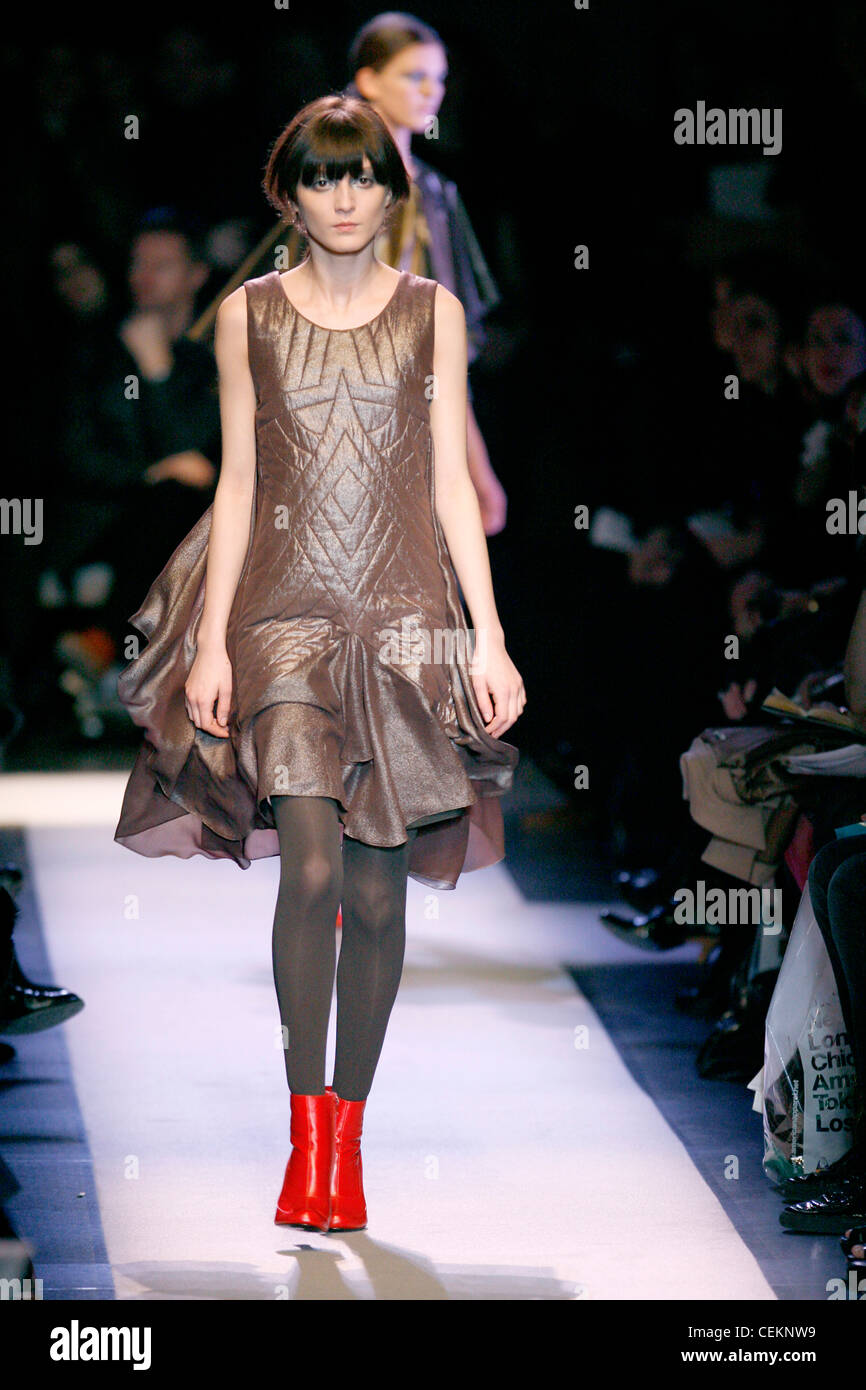 Rue du Mail Paris pronto a indossare in autunno e inverno donna che indossa un marrone metallico abito trapuntato con un mantello flounced Foto Stock