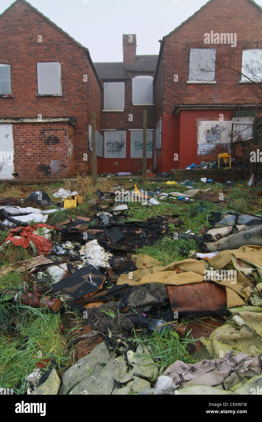 Case abbandonate con rubbished sparsi lungo i giardini Foto Stock