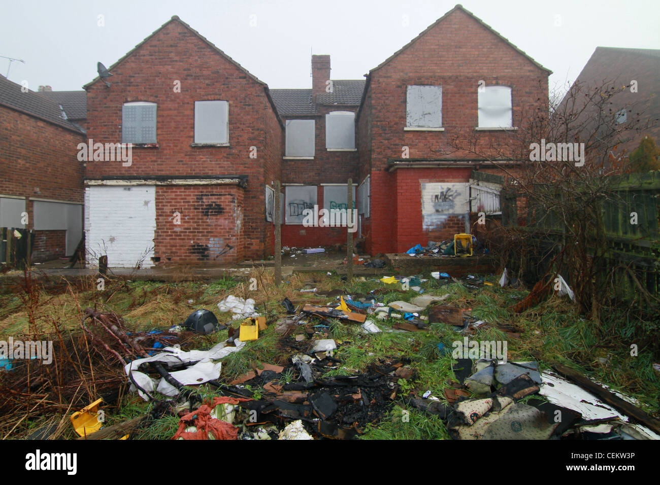 Case abbandonate con rubbished sparsi lungo i giardini Foto Stock