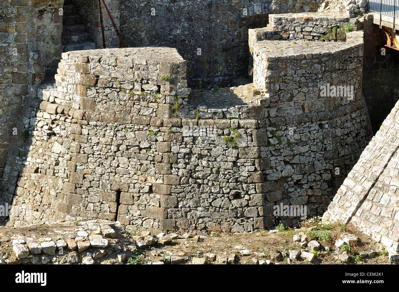 Le rovine del castello di Domfront, la base di una delle torri gemelle dell'entrata, tagliata come un diamante con molte sfaccettature. Foto Stock