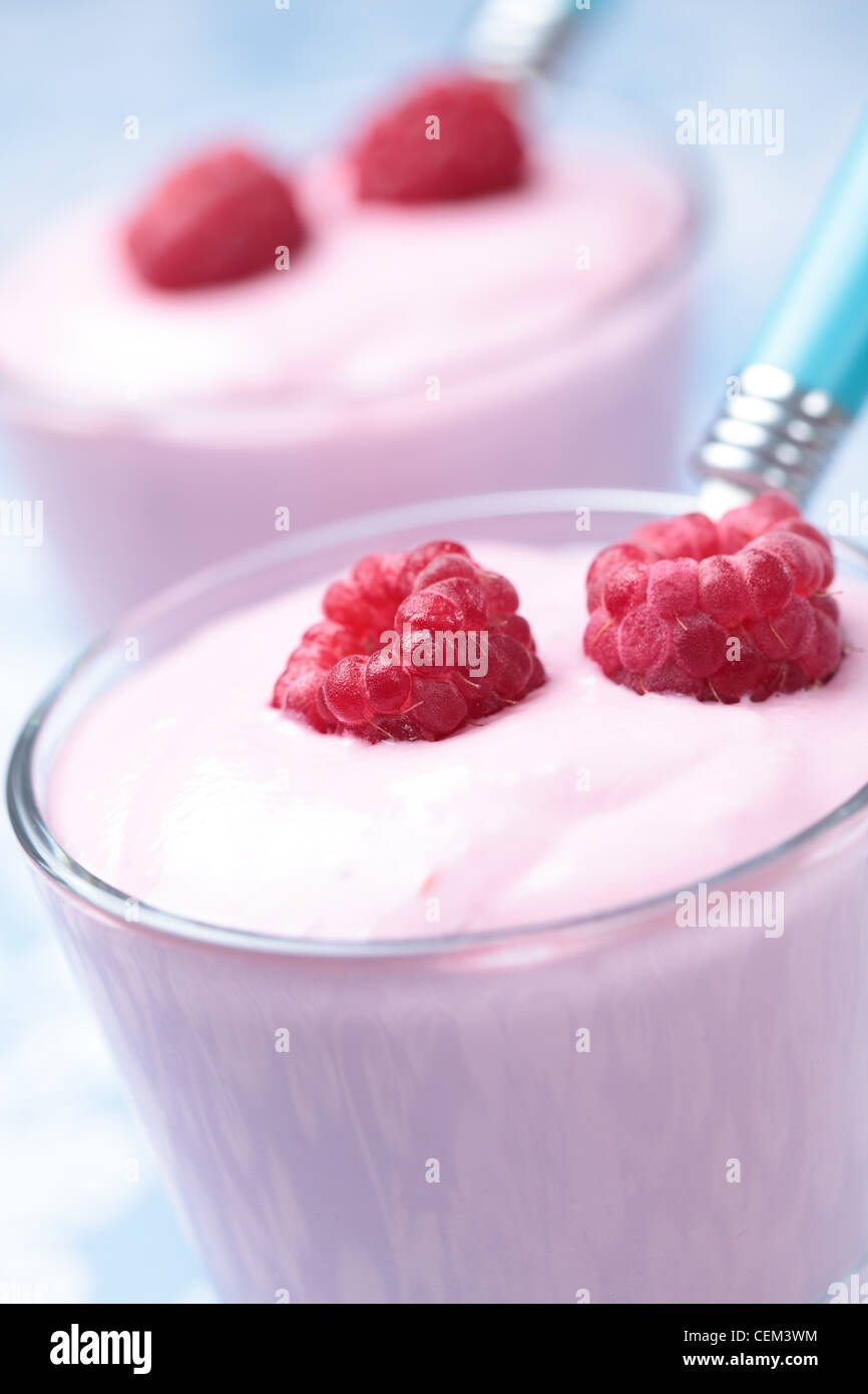 Lampone yogurt con frutti di bosco freschi in un bicchiere. DOF poco profondo Foto Stock