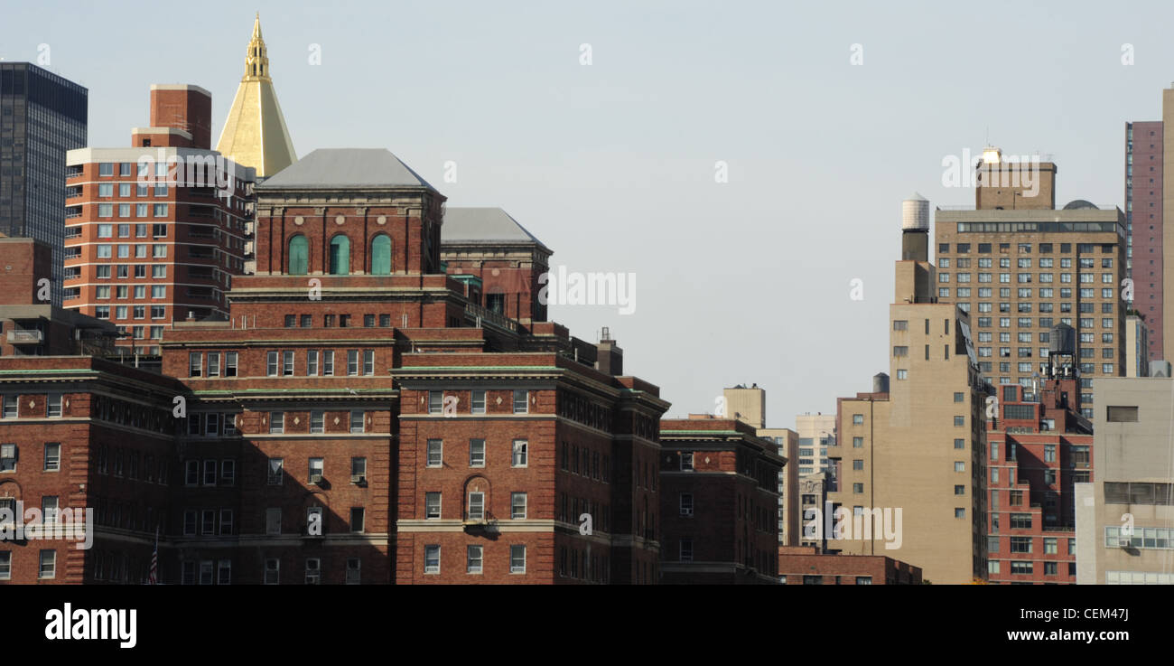 Cielo blu vista dall'East River, mattoni rossi Bellevue ospedale psichiatrico, oro NY Assicurazione sulla vita edificio, Kips Bay, New York Foto Stock