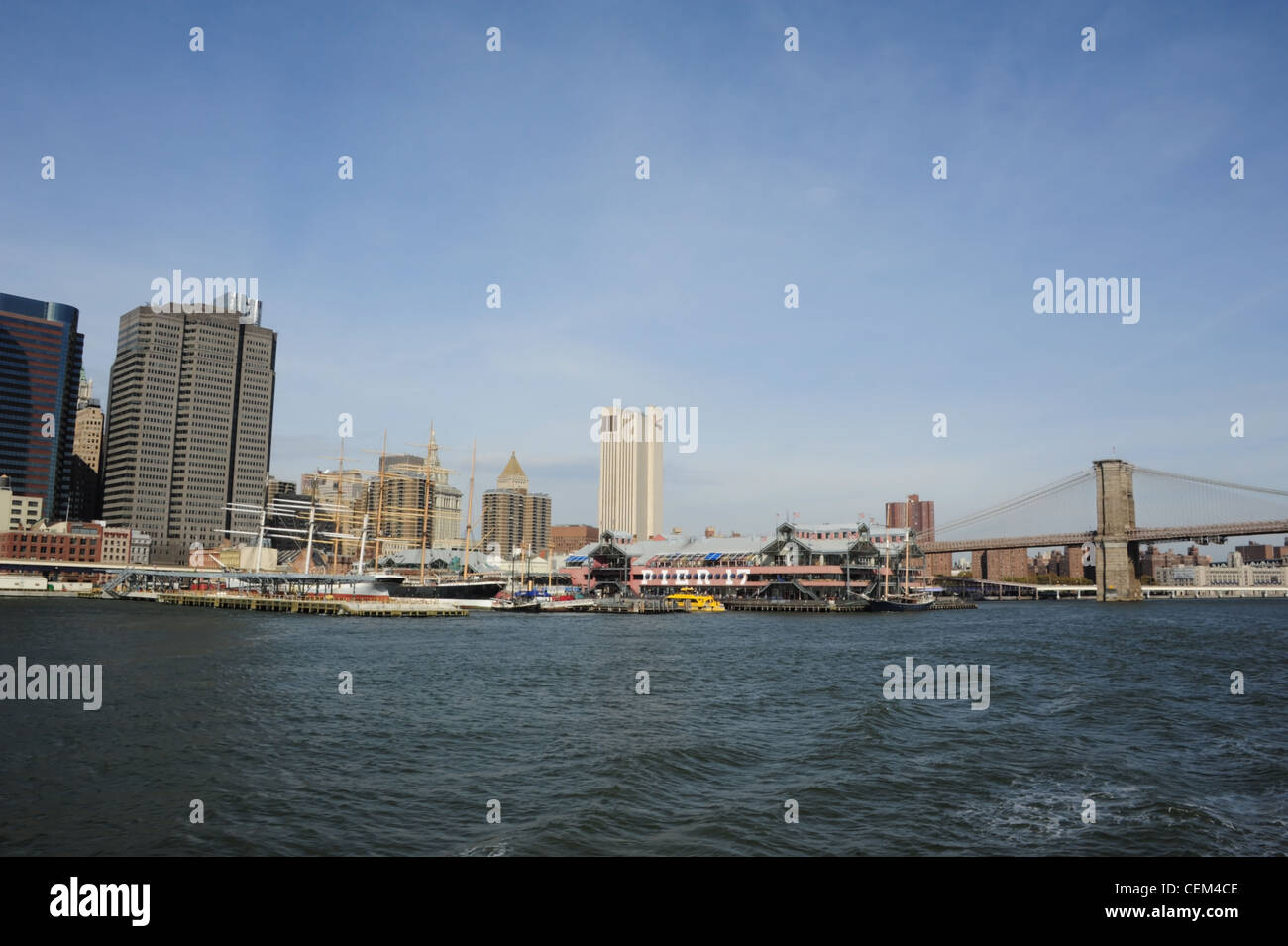 Cielo blu vista dall'East River, South Street Seaport Pier 17 Museum, grattacieli di Manhattan, Ponte di Brooklyn a New York Foto Stock