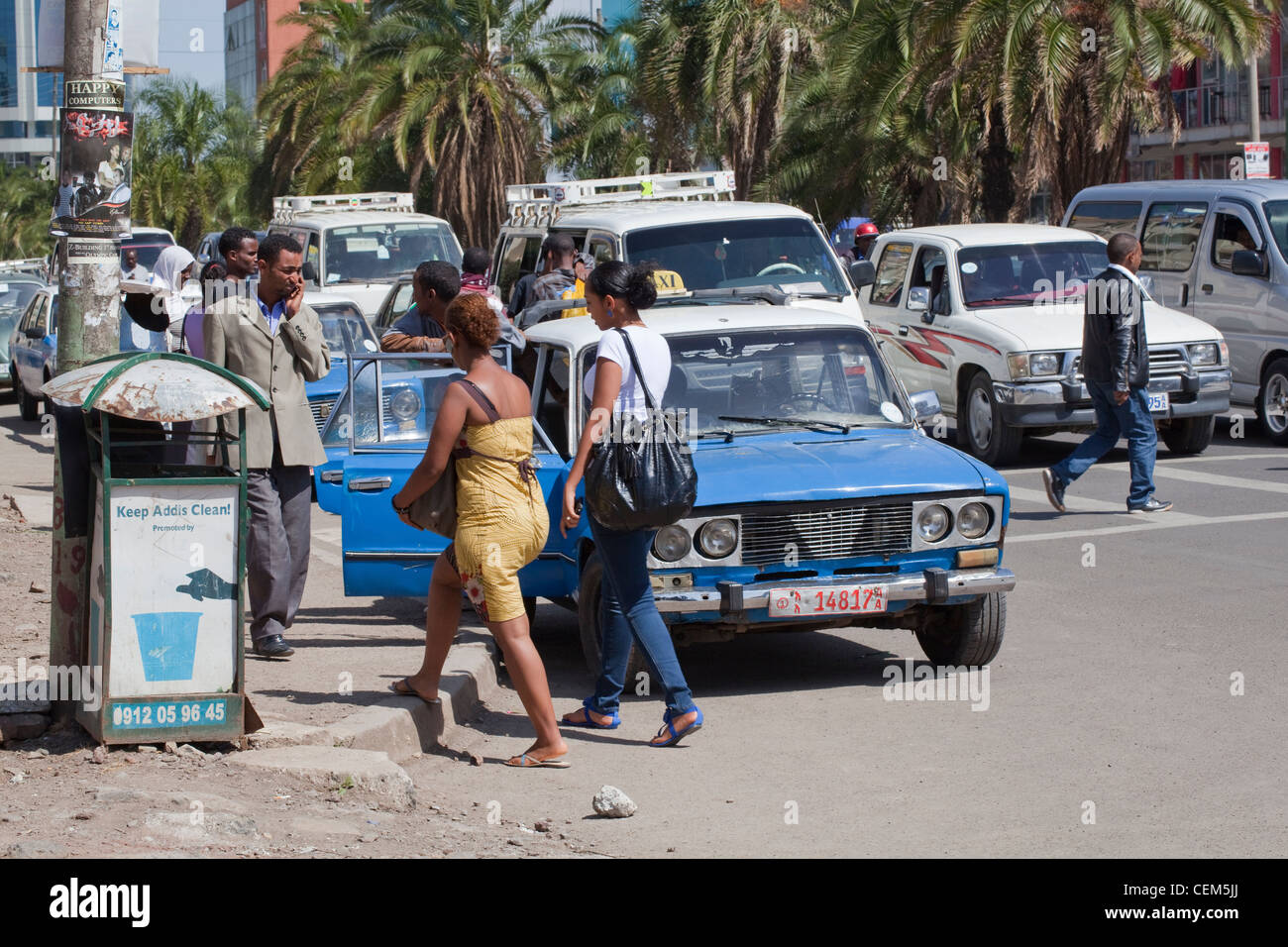 Etiopia ad Addis Abeba. Pedoni e traffico in corrispondenza di un incrocio stradale. Nota raccolta rifiuti bin sul marciapiede, a sinistra. Foto Stock