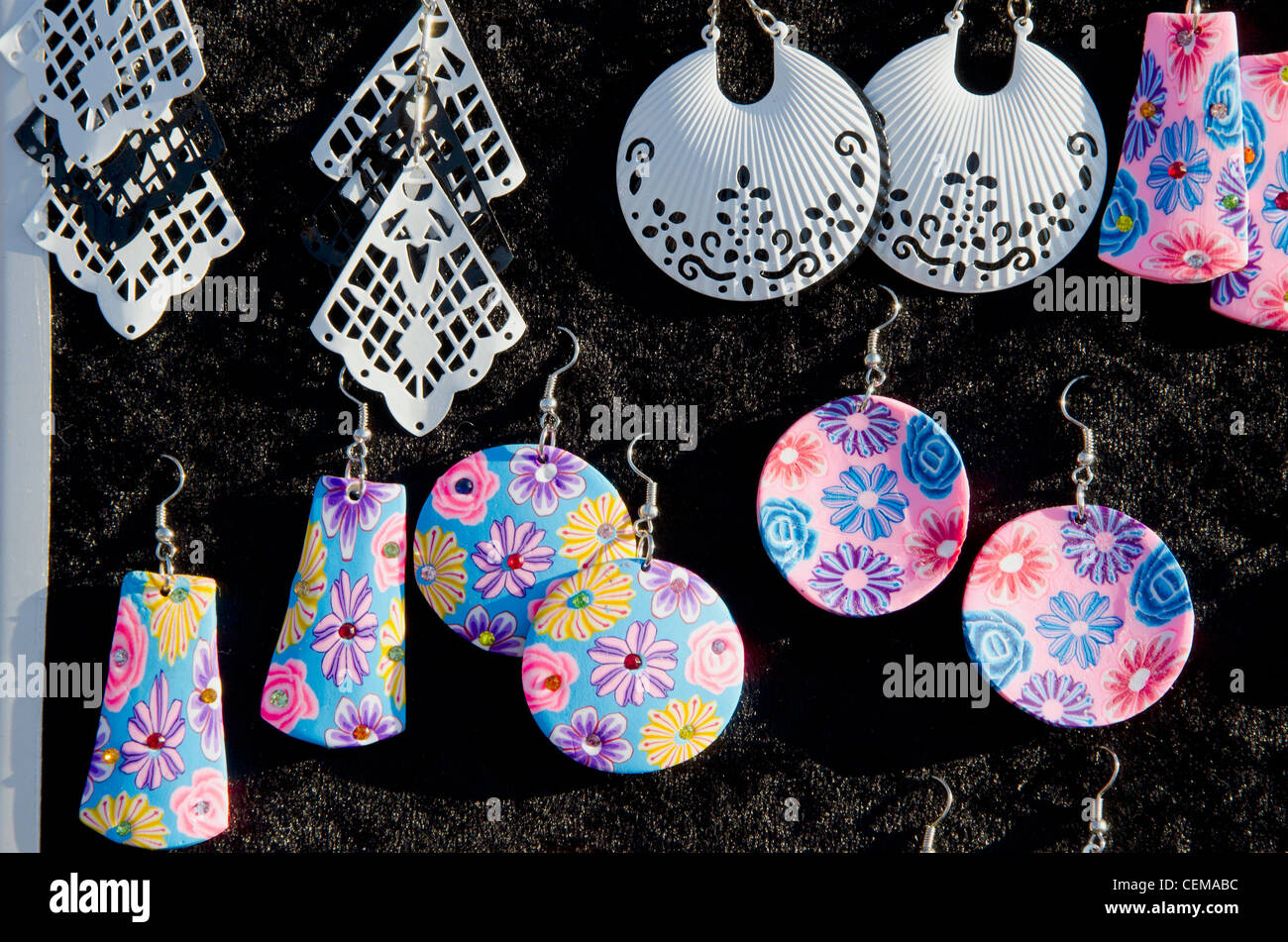 Colorati di varie forme decorative gioielli orecchini venduti in outdoor mercato equo. Foto Stock