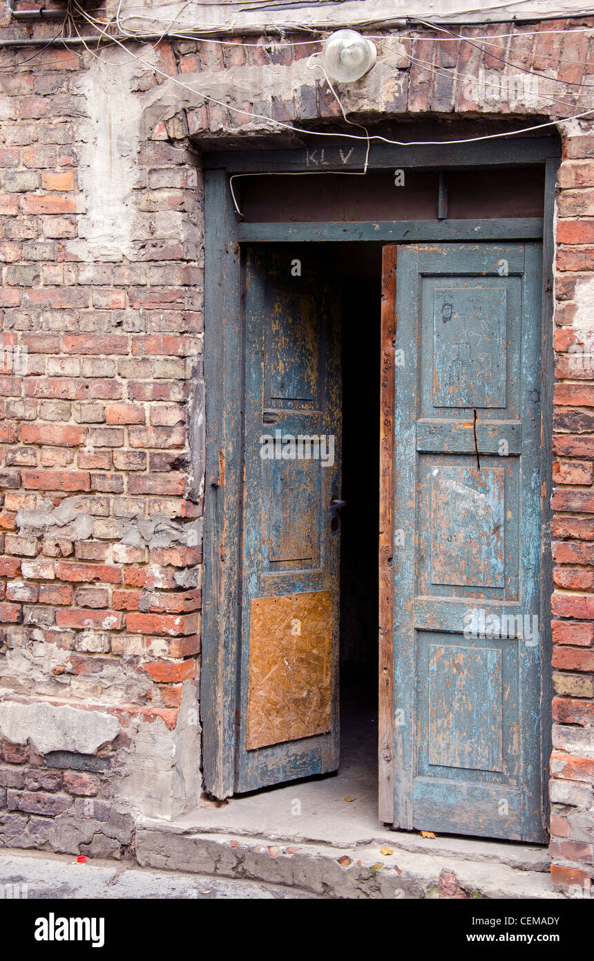 Grunge antica casa in muratura con ante in legno e mattoni rossi sullo sfondo della parete. Foto Stock