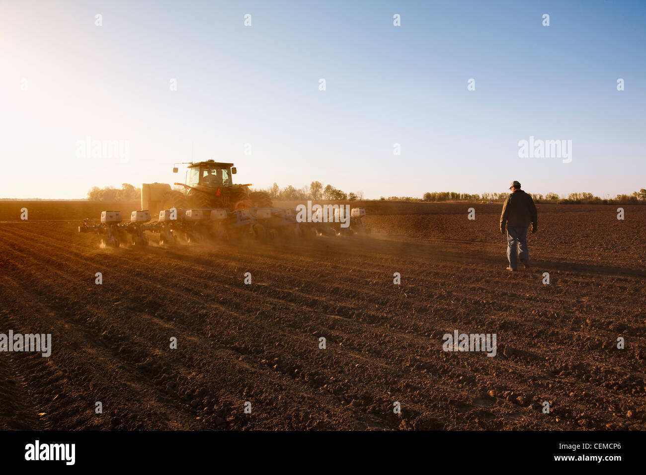 Agricoltura - UN trattore John Deere e Monosem 24 twin-la piantatrice a file di piante di mais granella in un coltivato convenzionalmente campo / Arkansas Foto Stock