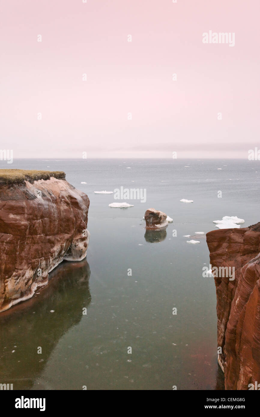 Roccia dal mare coperta di neve e ghiaccio, Iles de la Madeleine, Canada Foto Stock