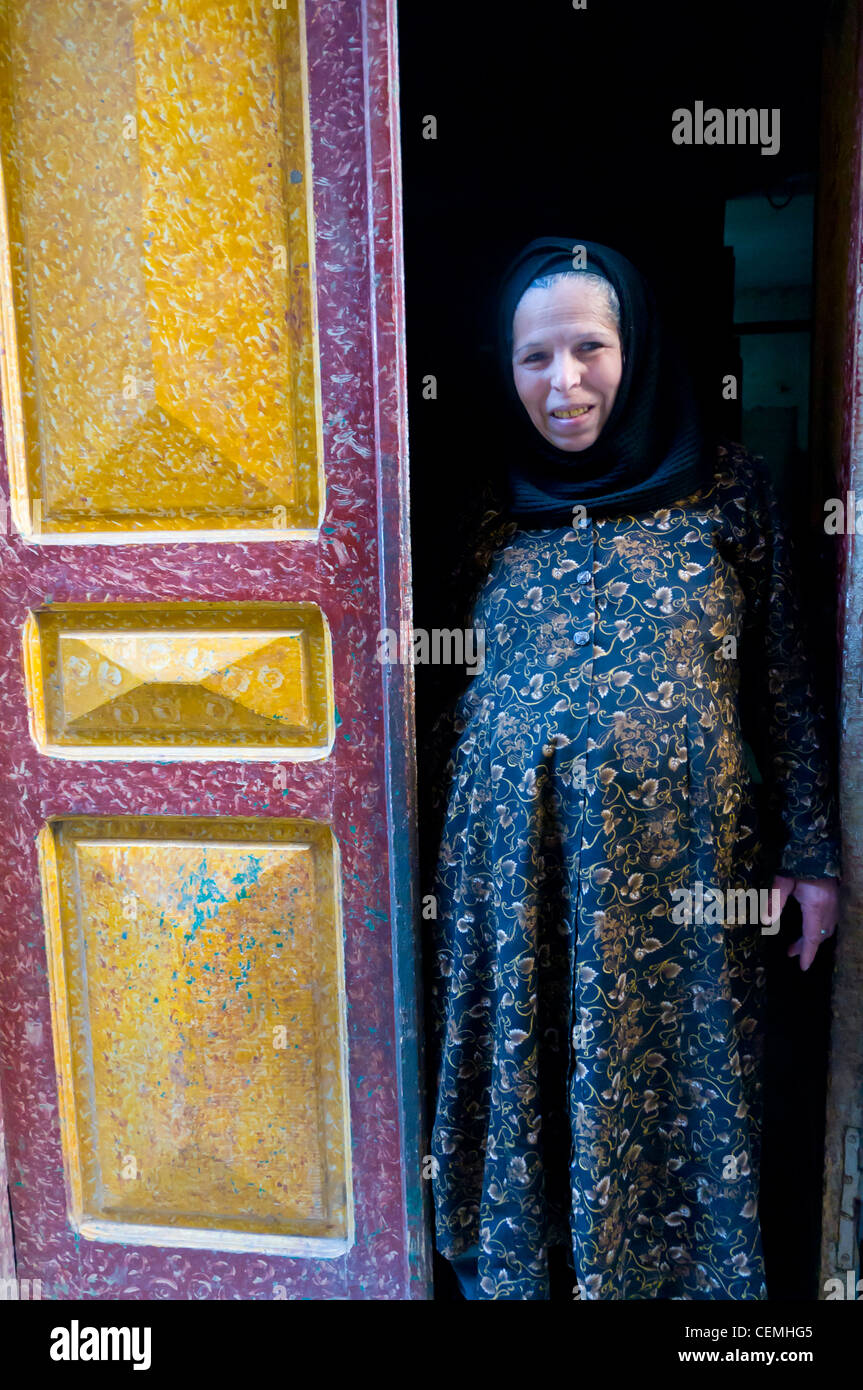Il copto donna in piedi alla porta della sua casa Minya Egitto Foto Stock