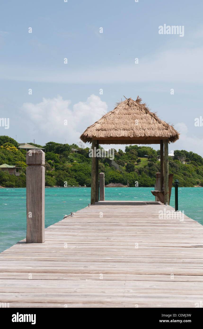 Tropical pontile in legno con capanna oltre il mare in Long Bay, Antigua Foto Stock