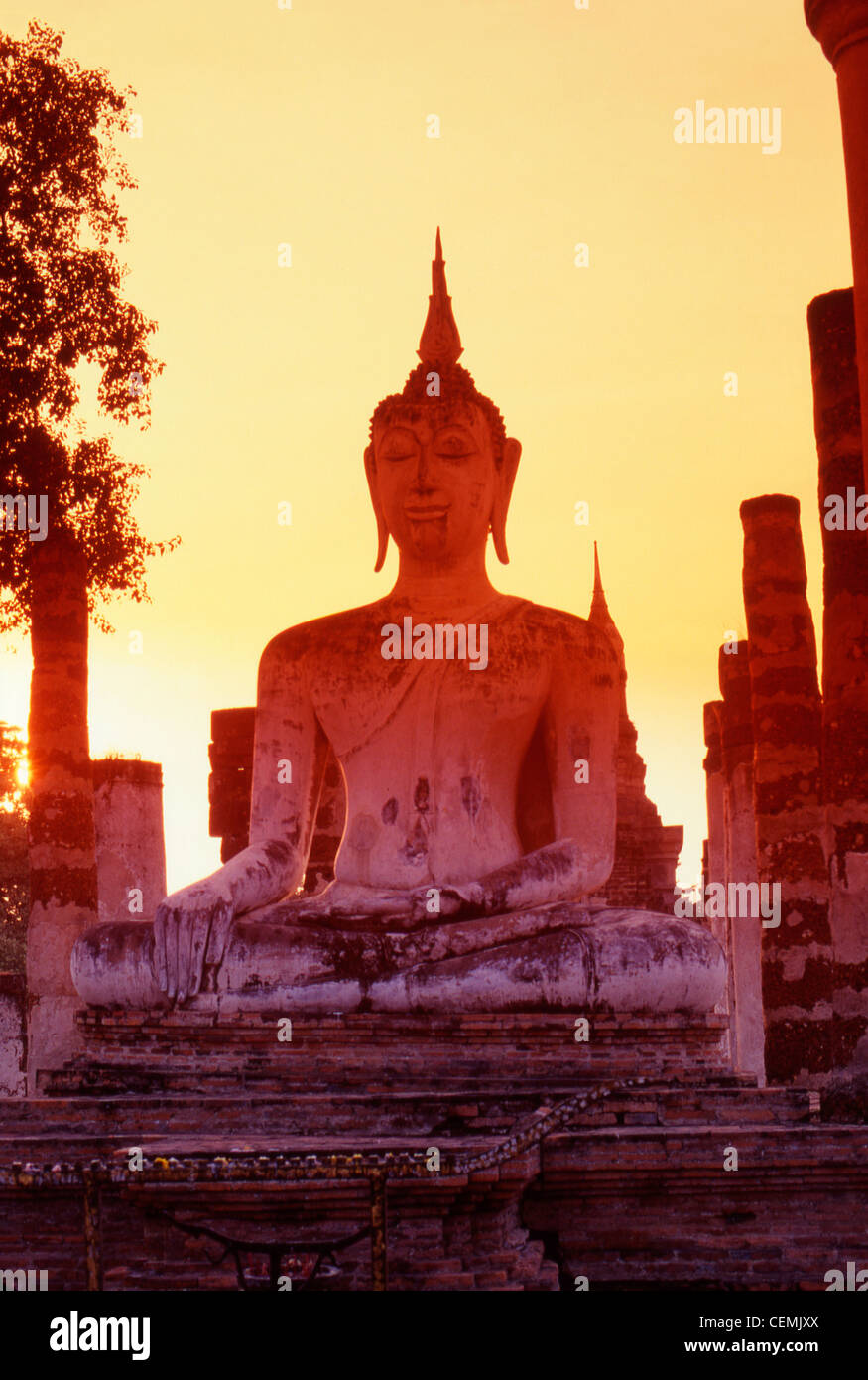 Tramonto sul Wat Mahathat statua del Buddha presso le antiche rovine di Sukothai, Thailandia Foto Stock