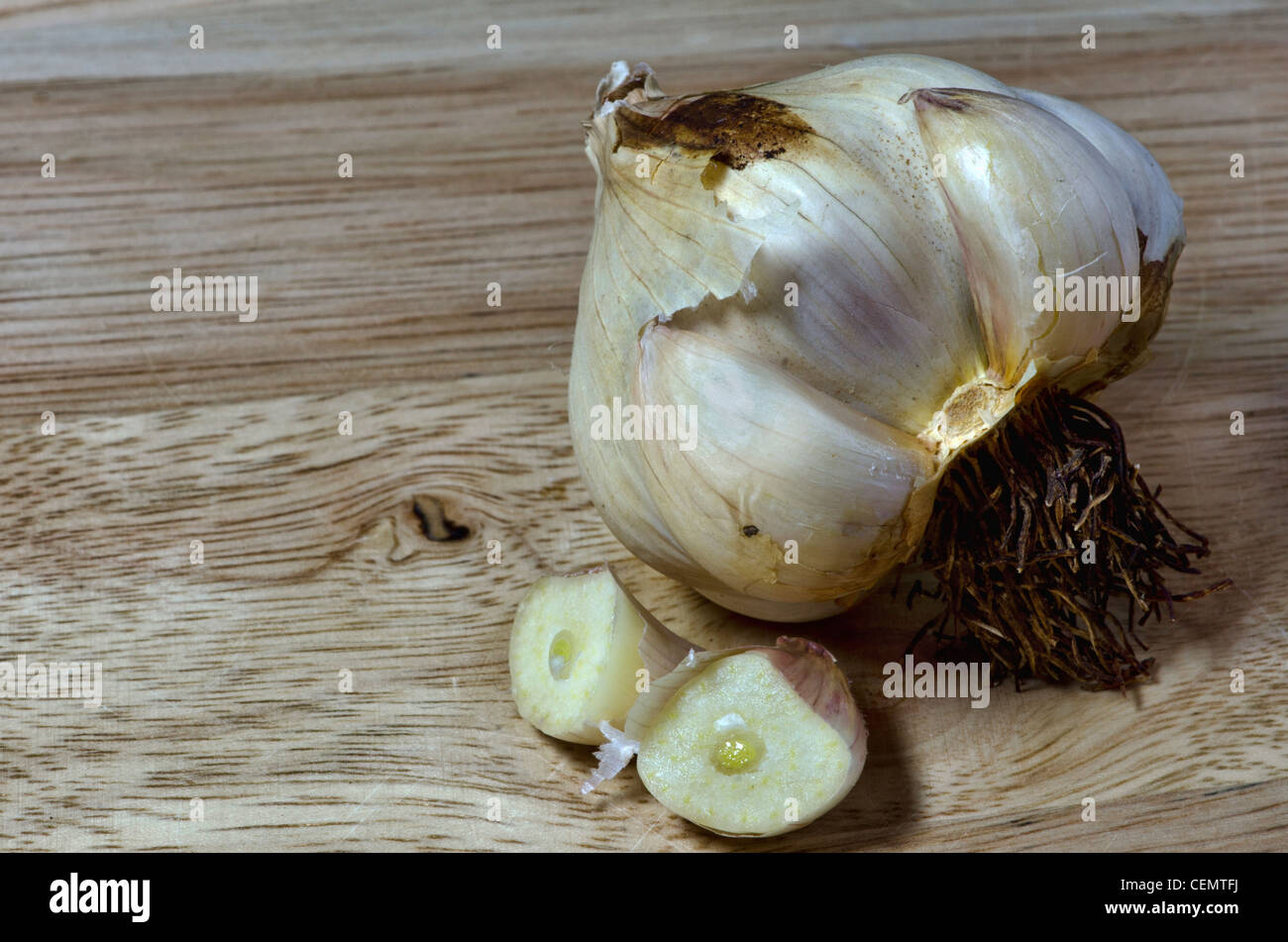 Aglio affumicato su legno tagliere Foto Stock