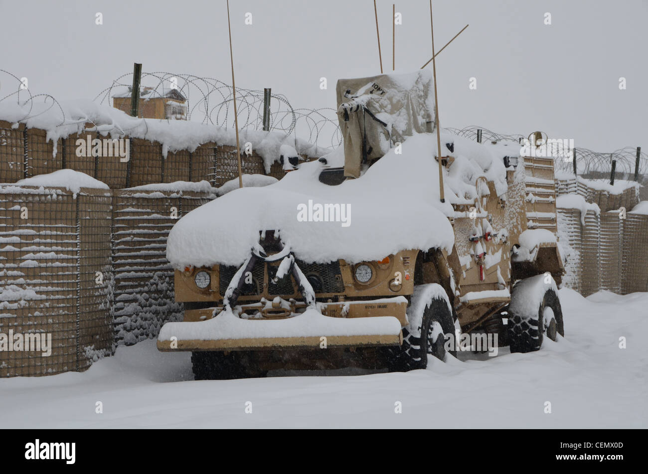 Una miniera resistente imboscata protetto veicolo fuoristrada è coperto con un altro coperta di neve ha ricevuto durante la notte in avanti su una base operativa bullard, Shah gioia, Afghanistan. Foto Stock