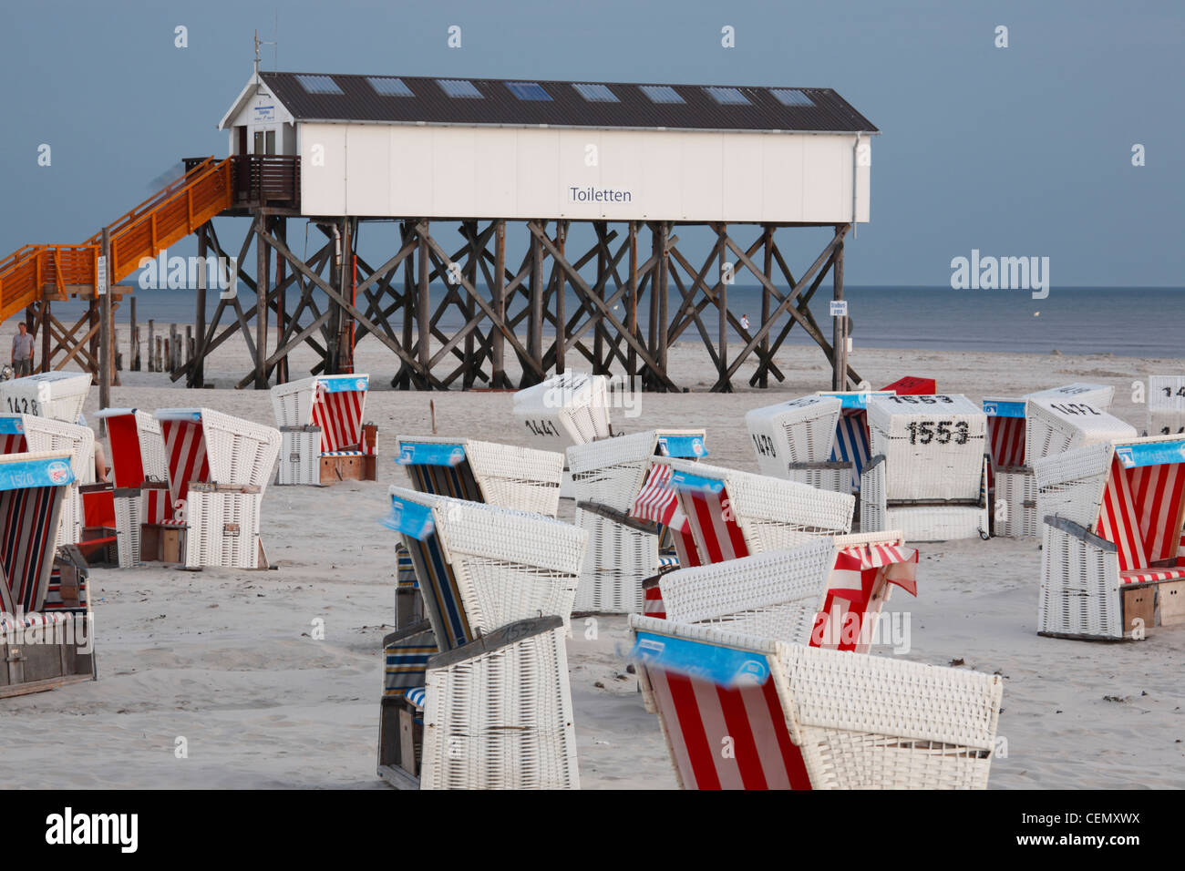 Sedie a sdraio e wc costruite su palafitte sulla San Peter-Ording beach, Germania Foto Stock