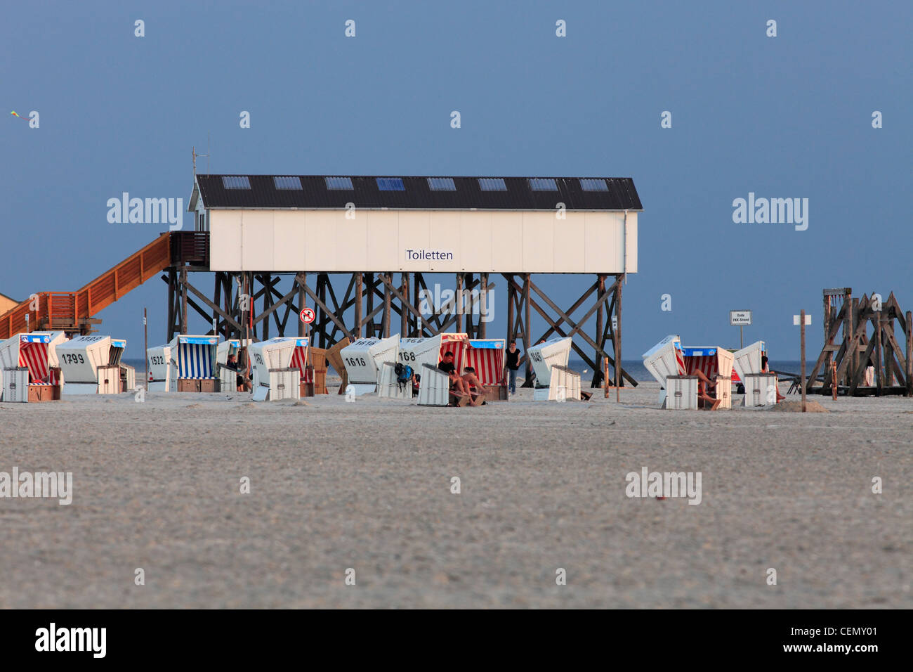 Sedie a sdraio e wc costruite su palafitte sulla San Peter-Ording beach, Germania Foto Stock