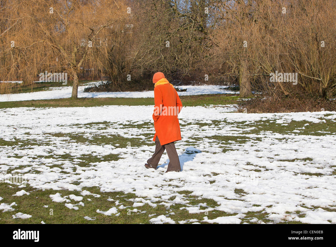 Una donna a piedi su una coperta di neve campo, Hampstead Heath, Highgate, London, England, Regno Unito Foto Stock