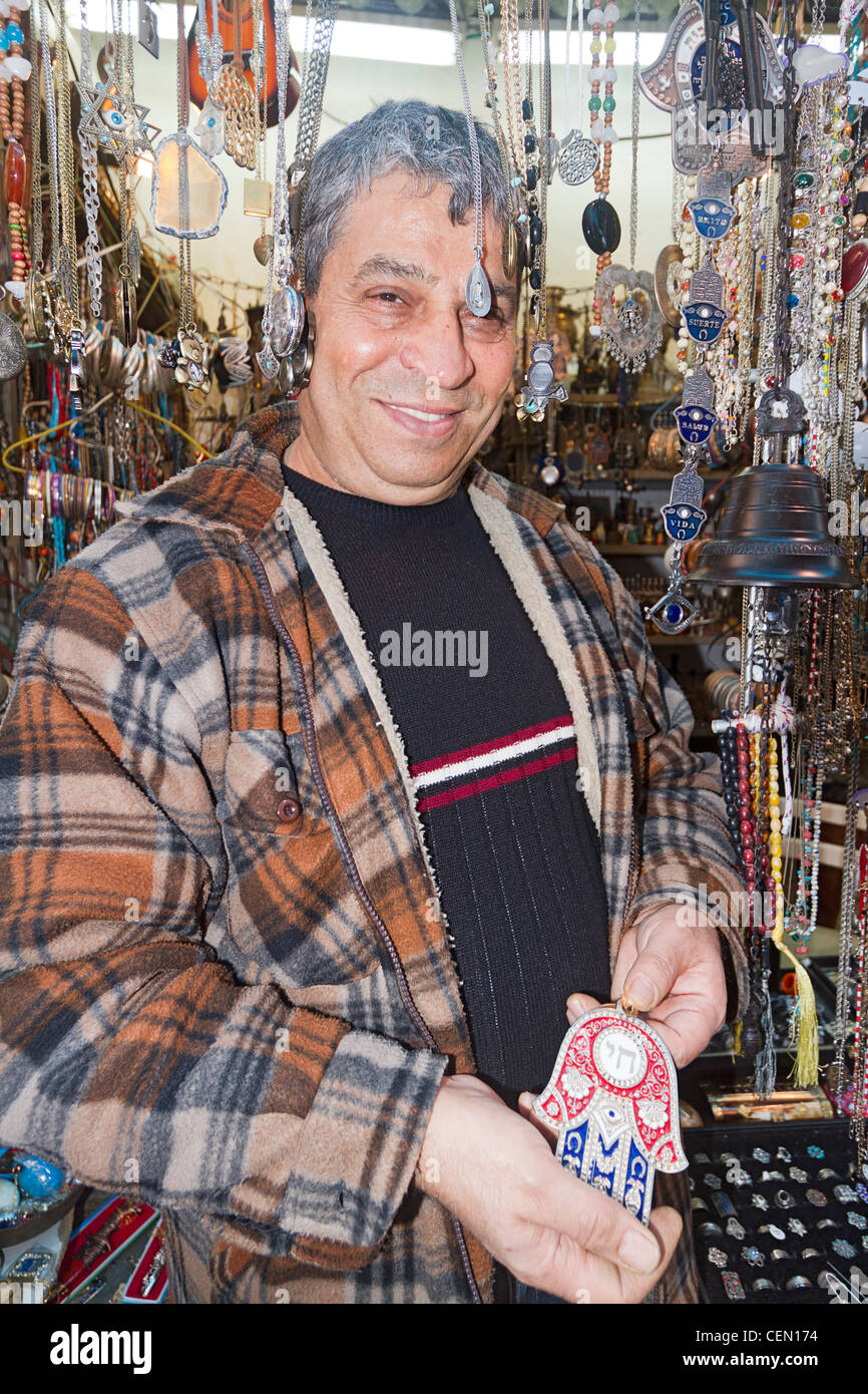 Commerciante locale mostra la HAMSA o "mano di Dio " gioielli in vendita. Foto Stock