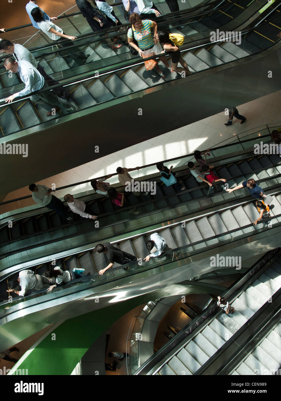 Shoppers cavalcare le scale mobili in VivoCity shopping mall di Singapore. Foto Stock