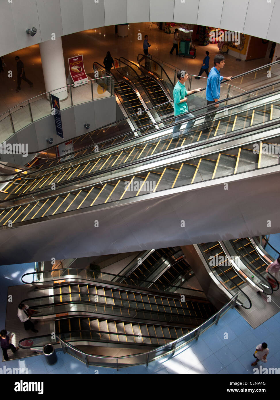 Shoppers cavalcare le scale mobili in VivoCity shopping mall di Singapore. Foto Stock