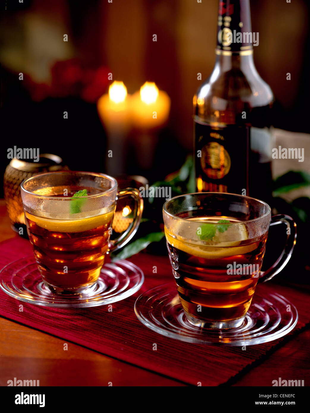 Natale caldo tè bevande rum, due bicchieri di vetro e piattini di tè di  frutta al rum e limone guarnita fetta di limone e melissa, su Foto stock -  Alamy