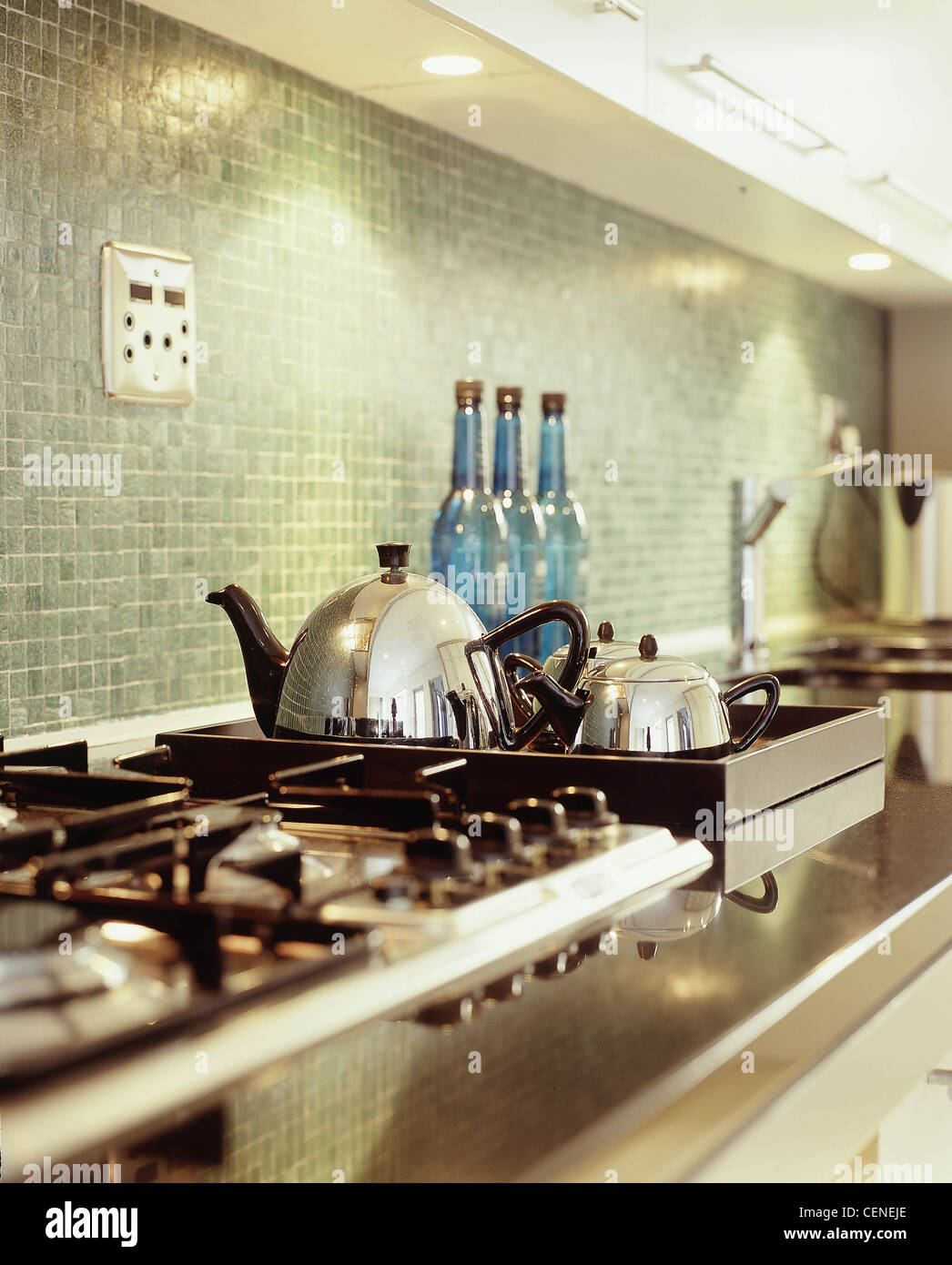 A tre diversi stili di cucina in marmo scuro di lavoro di cucina verde di superficie a mosaico splashback, piano di cottura e lavello incorporati in Foto Stock