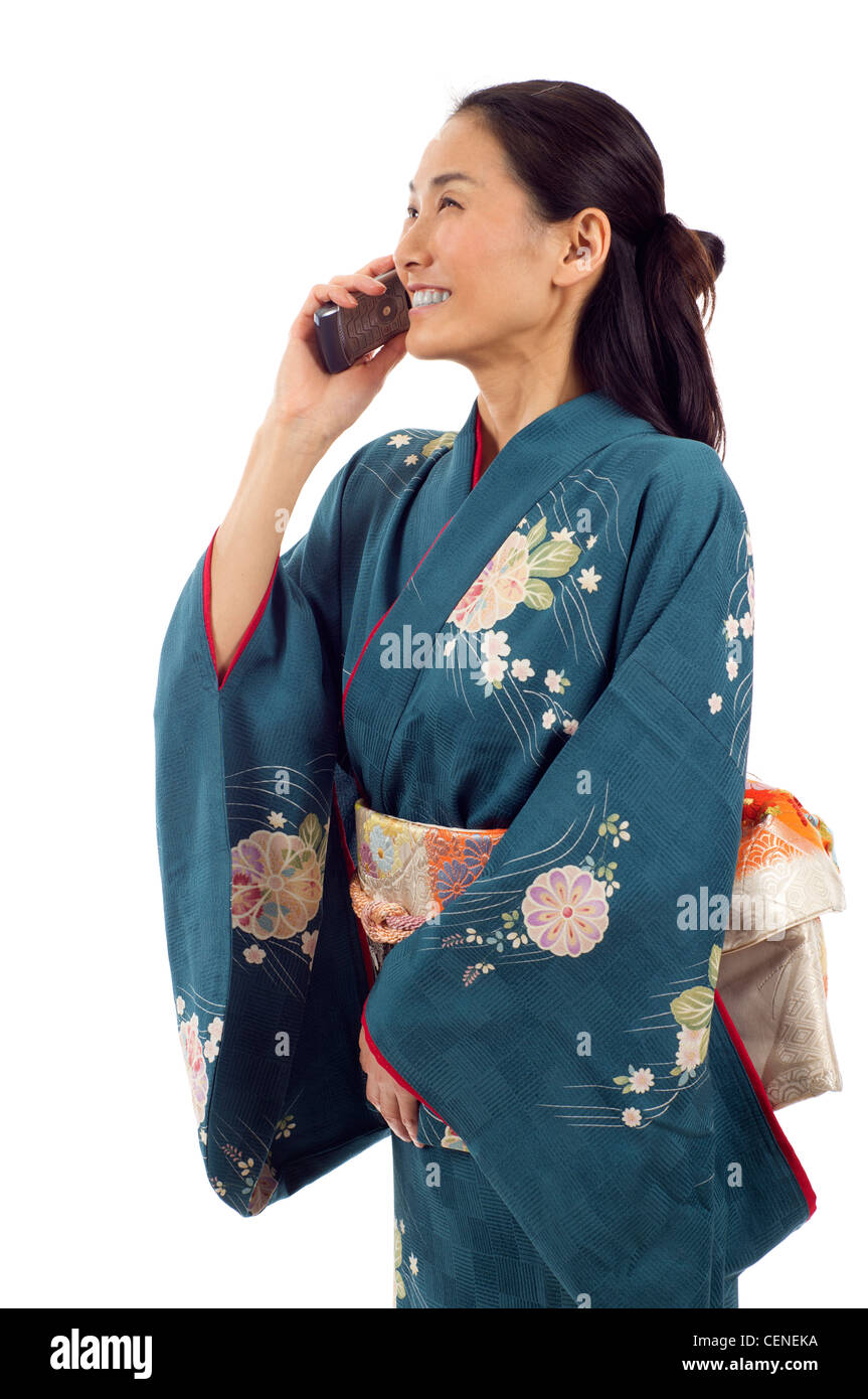 Donna Giapponese in kimono parlando al telefono isolato su sfondo bianco Foto Stock